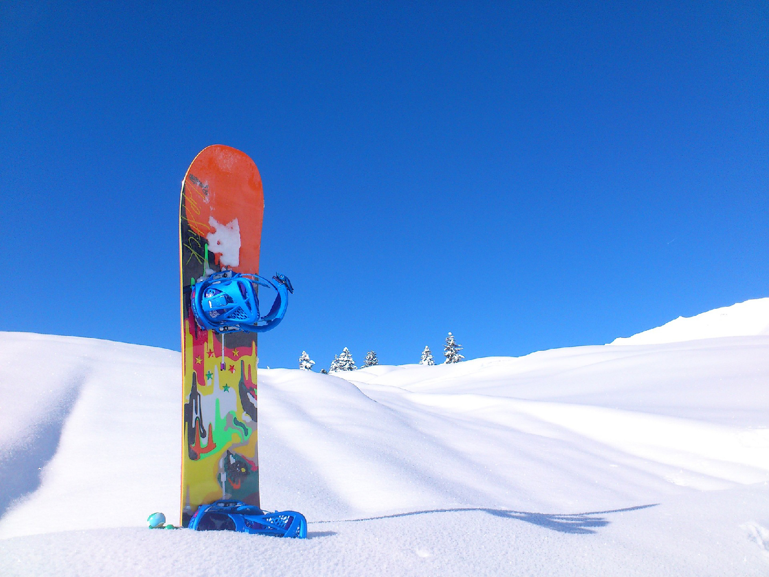 vermont snowboard sticking out of snow on a clear day. photo from pixabay by spinheike